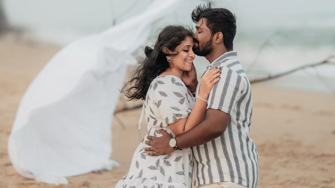 Couple on the beach, a white dupatta lifting in the wind